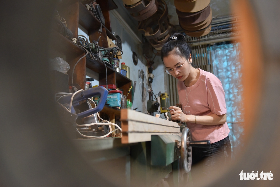 Thanh Tam measures the length of a guitar’s neck. Photo: Ngoc Phuong/Tuoi Tre