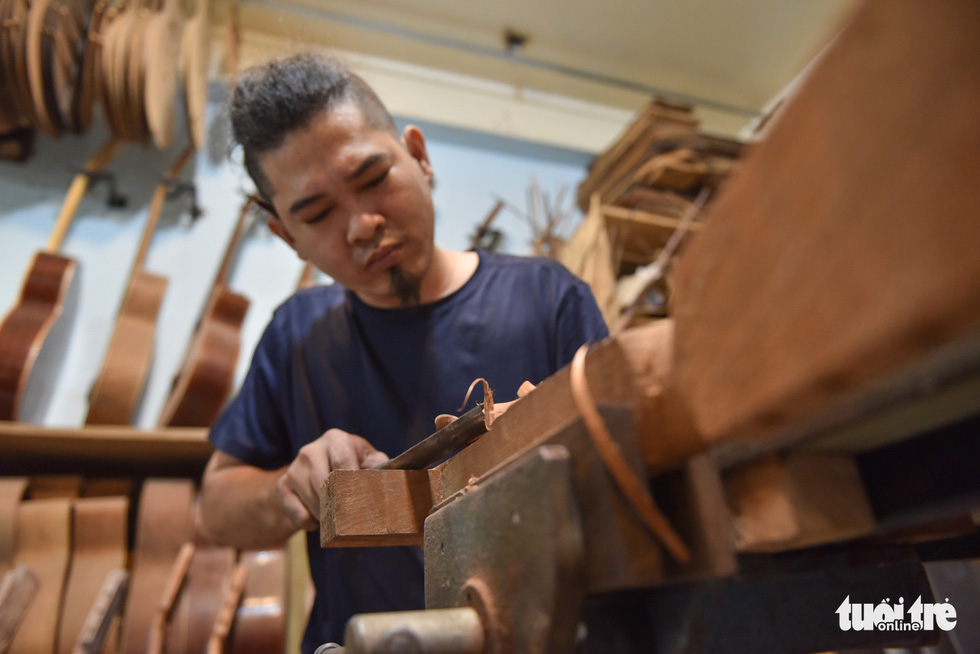 Buu Thang shapes a guitar’s neck to fit a customer’s order. Photo: Ngoc Phuong/Tuoi Tre