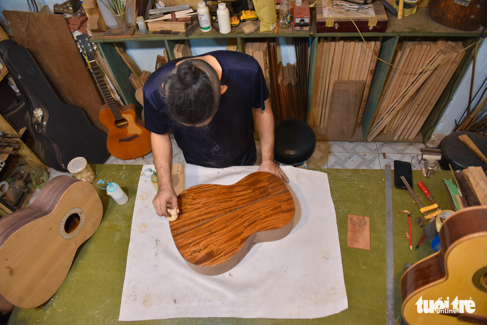 Buu Thang paints a sound box which decides how good a guitar will look. Photo: Ngoc Phuong/Tuoi Tre