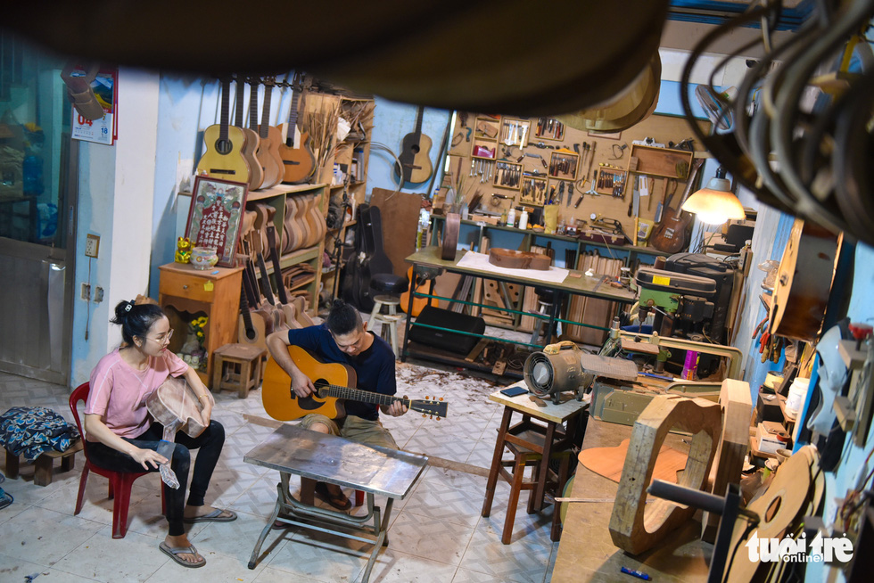 Thang tunes a guitar to check its sound. Photo: Ngoc Phuong/Tuoi Tre