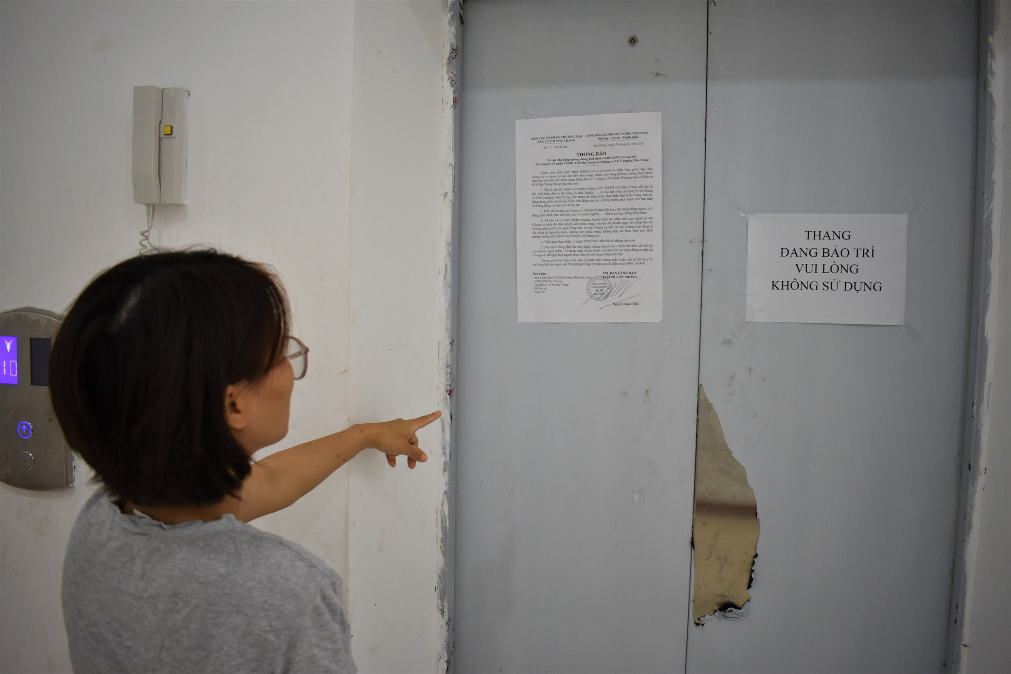 A woman points her finger at a shuttered elevator at the P.H Nha Trang apartment complex in Nha Trang City, Khanh Hoa Province, Vietnam. Photo: Minh Chien / Tuoi Tre