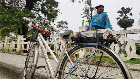Ton That Tam, a 70-year-old bicycle taxi driver, waits for potential customers on a daily basis at one end of Truong Tien Bridge, one of Hue City’s landmarks. Photo: Nhat Linh / Tuoi Tre