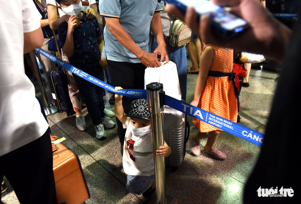 A tired little child stands among the waiting passengers at Tan Son Nhat International Airport in Ho Chi Minh City, April 18, 2021. Photo: Tuoi Tre