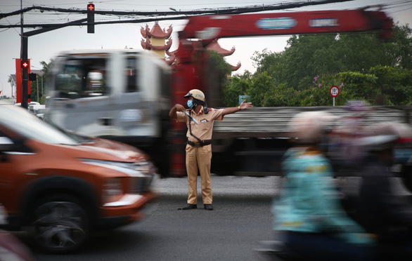 A traffic police officer on duty at a hot spot of traffic on National Highway 1 on May 2, 2021. Photo: Nhat Thinh / Tuoi Tre