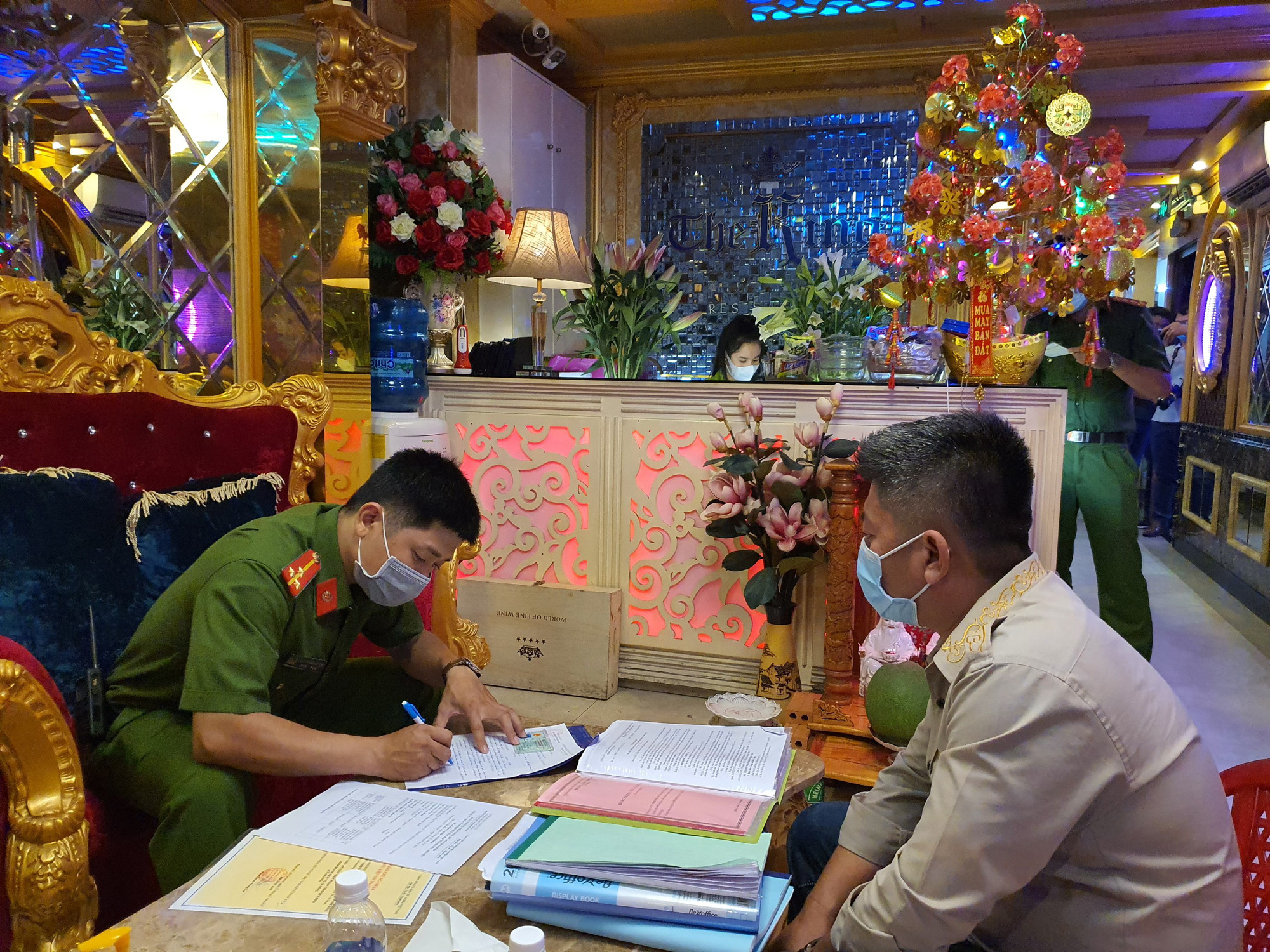 A police officer works with a representative of The King Restaurant in District 1, Ho Chi Minh City, May 4, 2021. Photo: D.T. / Tuoi Tre