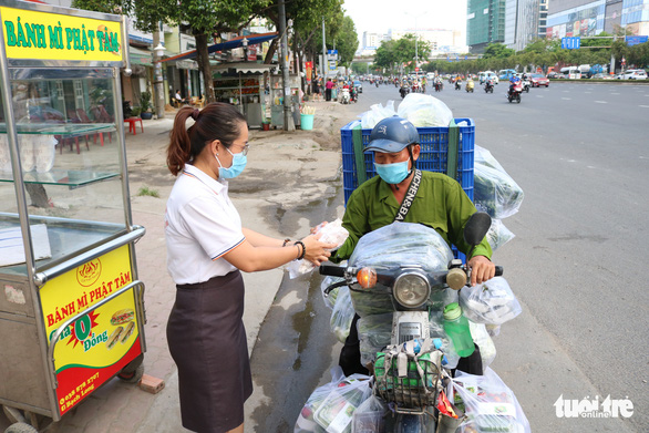A Phat Tam member gives a free sandwich to a laborer.  Photo: Hoang An / Tuoi Tre