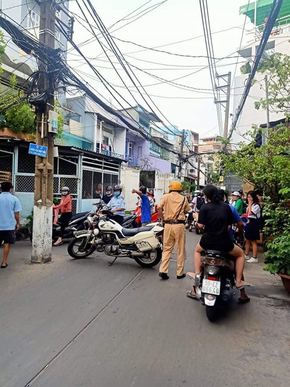 A traffic police officer regulates traffic in the alley where the fire occurs. Photo: M.H. / Tuoi Tre