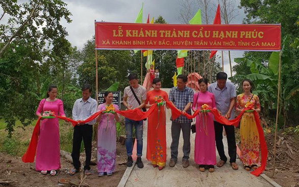 Nguyen Quan Tan (right) hands out free food for local people in flood-hit areas in Phuoc Son District in Quang Nam Province, Vietnam