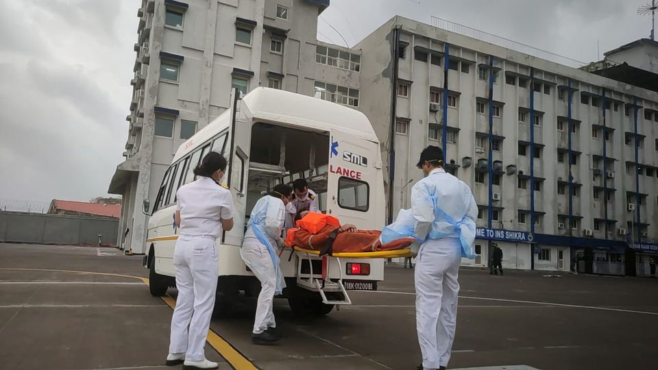 Members of the Indian Navy transport a person to receive medical attention after a rescue from a sunken barge in the Arabian Sea in the aftermath of cyclone Tauktae's landfall, at naval air station INS Shikra in Mumbai, May 18, 2021. Indian Navy/Handout via Reuters