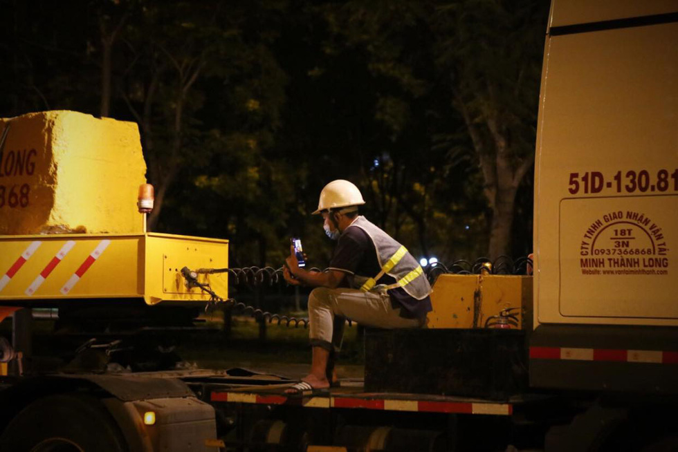 A worker handles a technical error during the transportation of the fourth train for Ho Chi Minh City’s metro line No. 1 to the Long Binh Depot in Thu Duc City, June 21, 2021. Photo: Nhat Thinh / Tuoi Tre