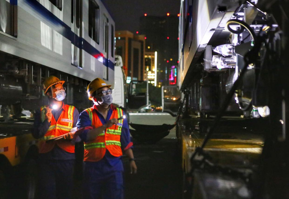 Technical workers check technical safety before the transportation of the fourth train for Ho Chi Minh City’s metro line No. 1 to the Long Binh Depot in Thu Duc City, June 21, 2021. Photo: Nhat Thinh / Tuoi Tre
