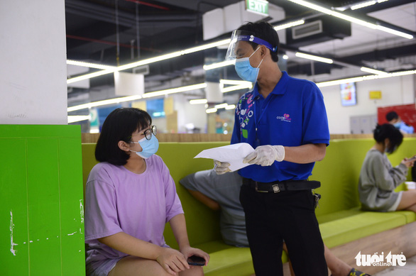 A staffer of a Co.opmart supermarket in Ho Chi Minh City asks a customer to supersede a sold-out item on her order. Photo: Quang Dinh / Tuoi Tre
