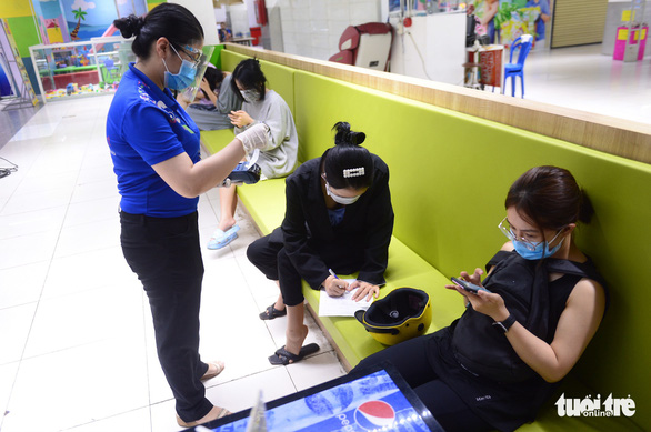 A customer in a Co.opmart supermarket in Ho Chi Minh City pays with a credit card for her pickup order. Photo: Quang Dinh / Tuoi Tre