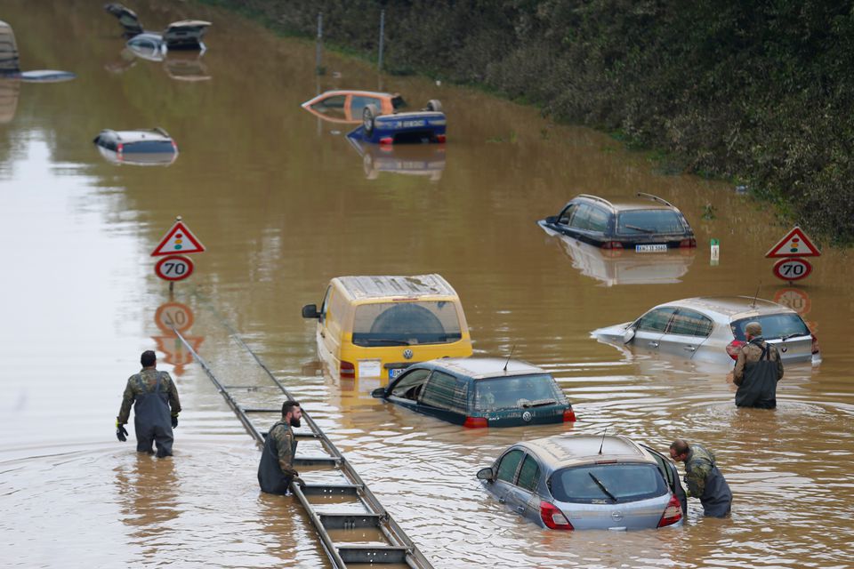Members of the Bundeswehr forces, surrounded by partially submerged cars, wade through the flood water following heavy rainfalls in Erftstadt-Blessem, Germany, July 17, 2021.  Photo: Reuters
