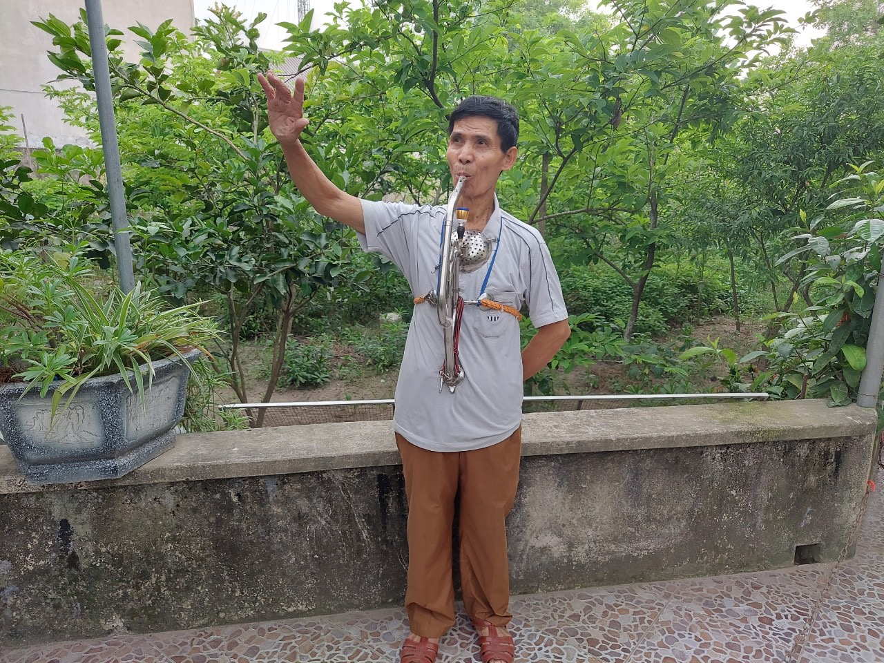 Chu Dinh Hoa is seen playing a musical instrument he created for people with disabilities. Photo provided by Hoa