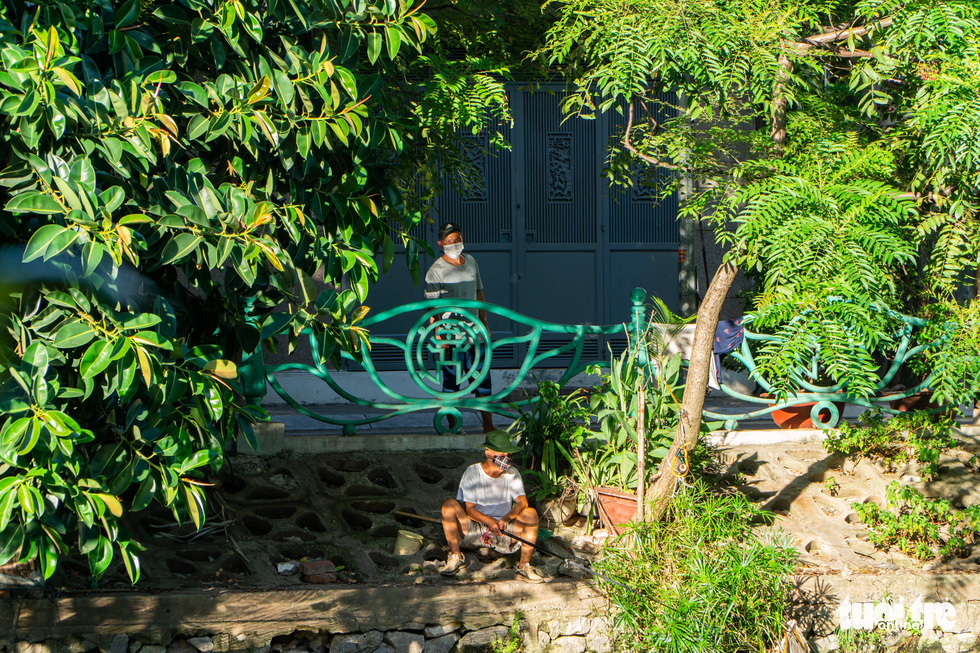 A Hanoi resident fishes on Nguyen Dinh Thi Street of Hanoi, July 27, 2021. Photo: Pham Tuan / Tuoi Tre