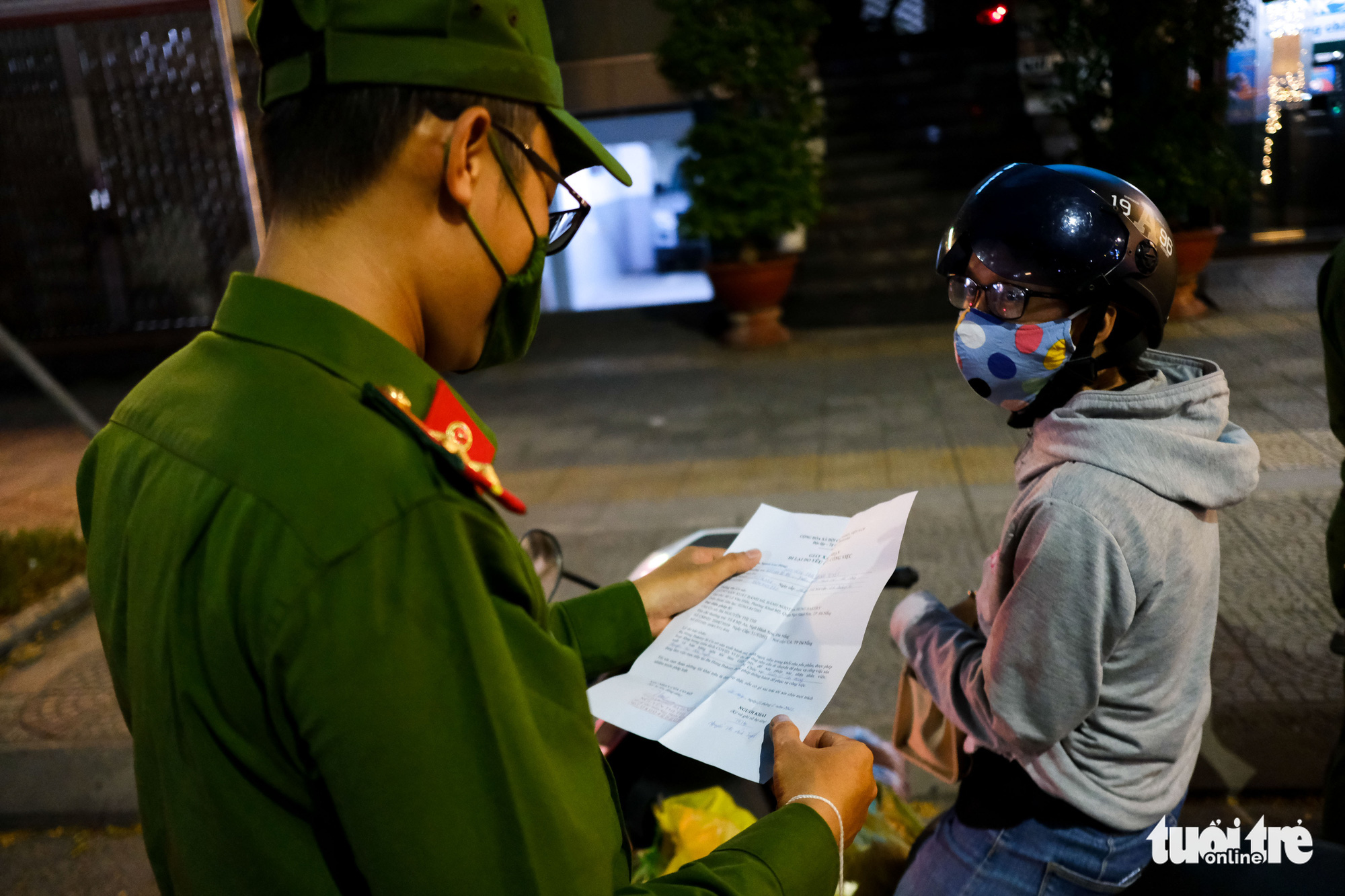 An officer checks documents of a commuter in Da Nang, July 31, 2021. Photo: Tan Luc / Tuoi Tre