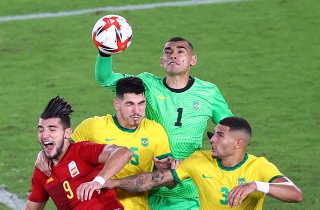 Tokyo 2020 Olympics - Soccer Football - Men - Gold medal match - Brazil v Spain - International Stadium Yokohama, Yokohama, Japan - August 7, 2021. Santos of Brazil punches clear of Nino of Brazil, Diego Carlos of Brazil and Rafa Mir of Spain. Photo: Reuters