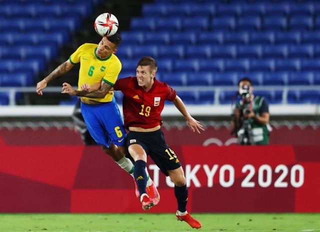 Tokyo 2020 Olympics - Soccer Football - Men - Gold medal match - Brazil v Spain - International Stadium Yokohama, Yokohama, Japan - August 7, 2021. Guilherme Arana of Brazil in action with Dani Olmo of Spain. Photo: Reuters