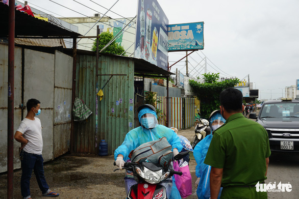 A police officer is seen giving explanations to people leaving Ho Chi Minh City on August 15, 2021. Photo: Duc Phu / Tuoi Tre