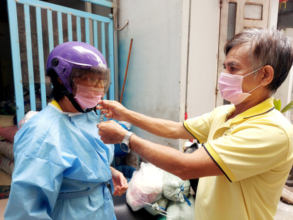 Nguyen Van Tuong helps his wife to take a quick COVID-19 test before giving food to the needy. Photo: Chi Cong / Tuoi Tre
