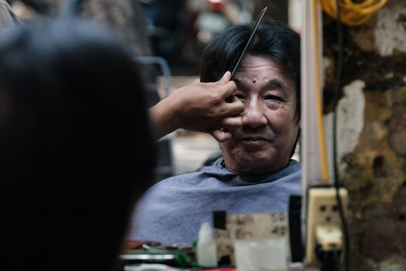 A resident gets a haircut at a barbershop in Dong Da District, Hanoi, September 21, 2021. Photo: Mai Thuong / Tuoi Tre