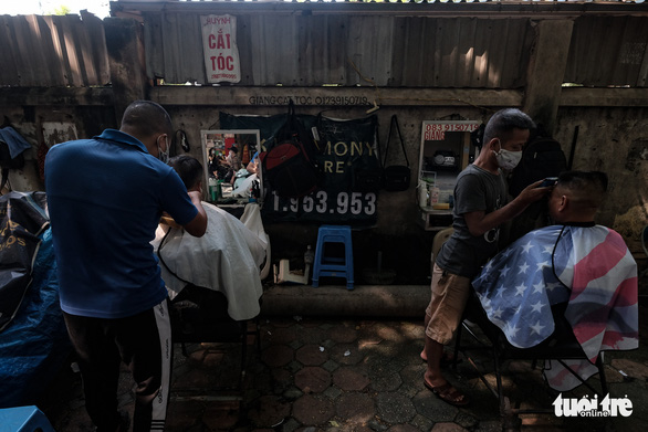 Residents get haircuts at street barbershops on Thai Thinh Street, Dong Da District, Hanoi, September 21, 2021. Photo: Mai Thuong / Tuoi Tre