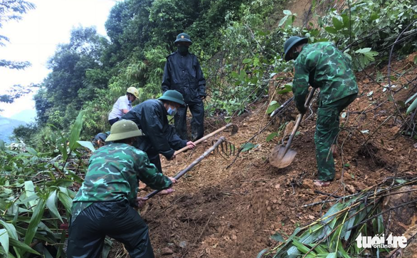 Border guard officers remove debris from a road hit by a landslide in Ky Son District, Nghe An Province, Vietnam. Photo: Le Thach / Tuoi Tre