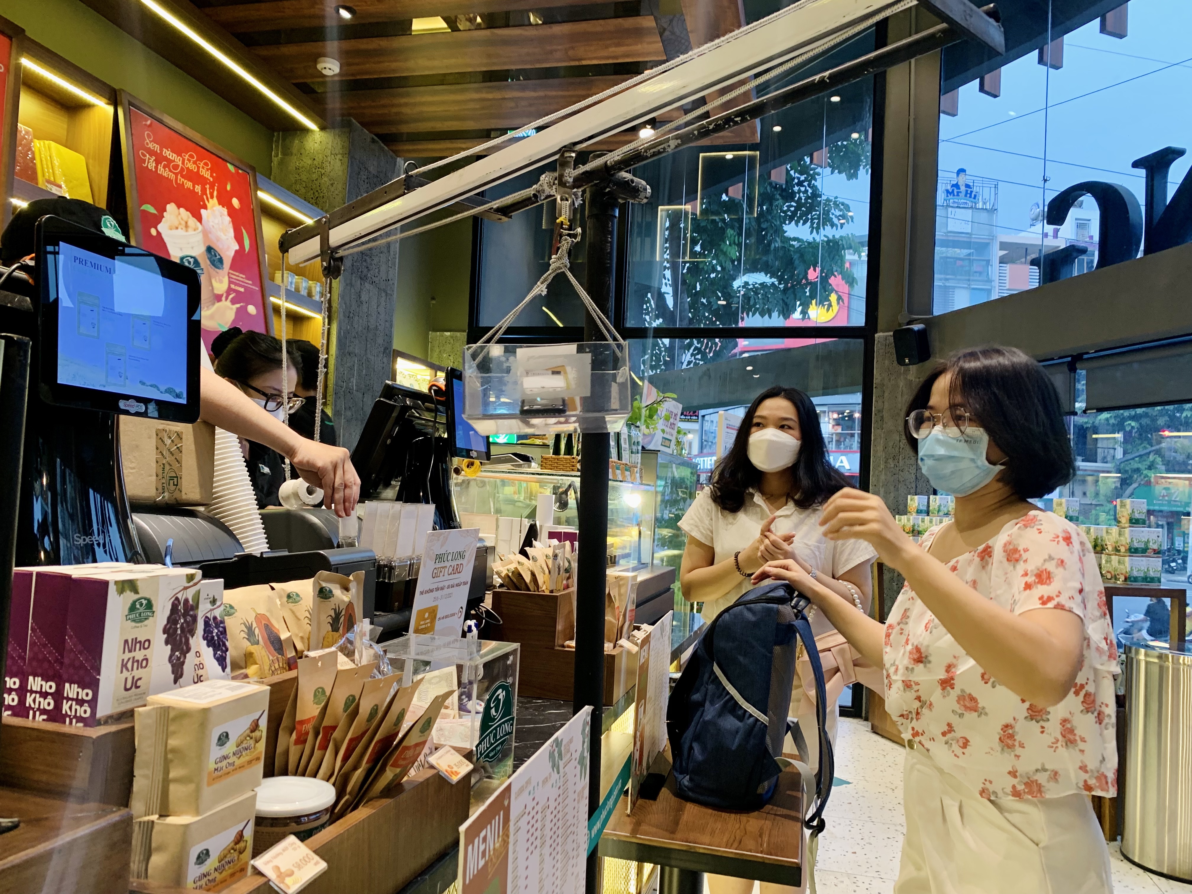 Customers put money in a box to avoid contact with staffers at a tea shop in Binh Thanh District, Ho Chi Minh City, November 2021. Photo: Bong Mai / Tuoi Tre
