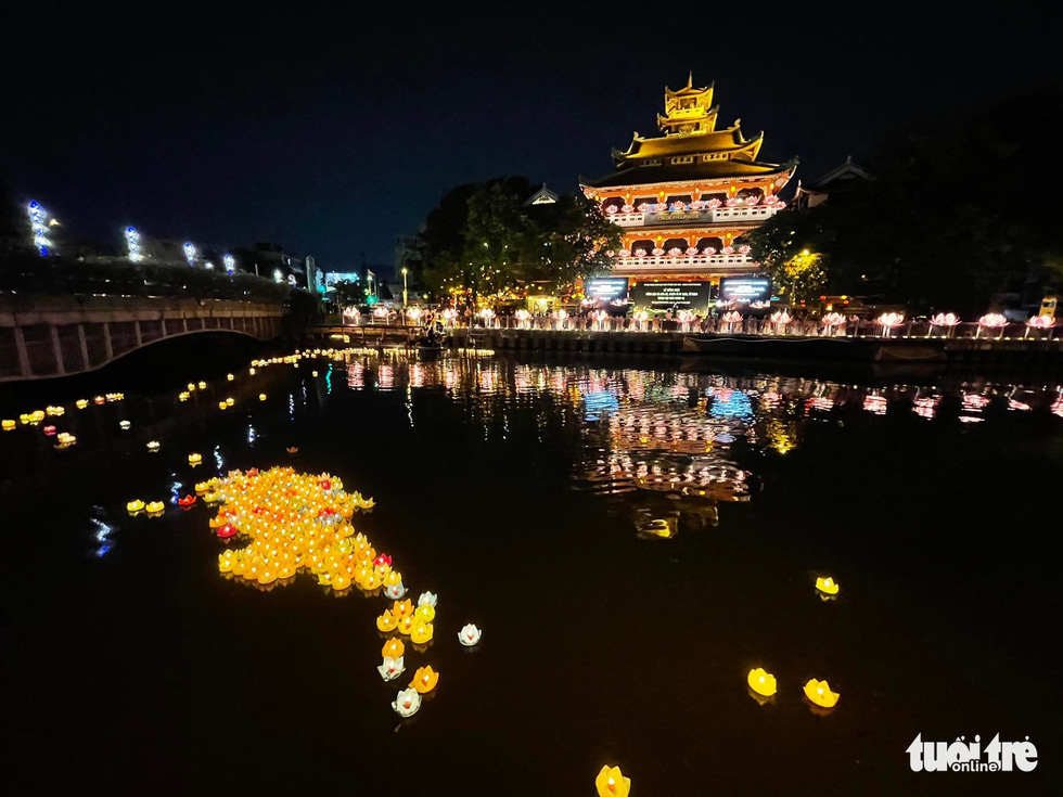 Flower lanterns are dropped on Nhieu Loc - Thi Nghe Canal in Ho Chi Minh City on the evening of November 19, 2021 as a tribute to people who died from COVID-19. Photo: Le Phan / Tuoi Tre
