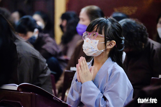 A nine-year-old student in Hanoi is seen attending the memorial service for COVID-19 victims  at Quan Su Pagoda in Hanoi on November 19, 2021. Photo: Nam Tran / Tuoi Tre