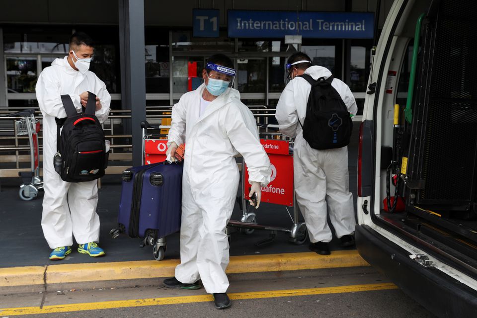 Travellers in personal protective equipment load luggage into a taxi outside the international terminal at Sydney Airport, as countries react to the new coronavirus Omicron variant amid the coronavirus disease (COVID-19) pandemic, in Sydney, Australia, November 29, 2021. Photo: Reuters