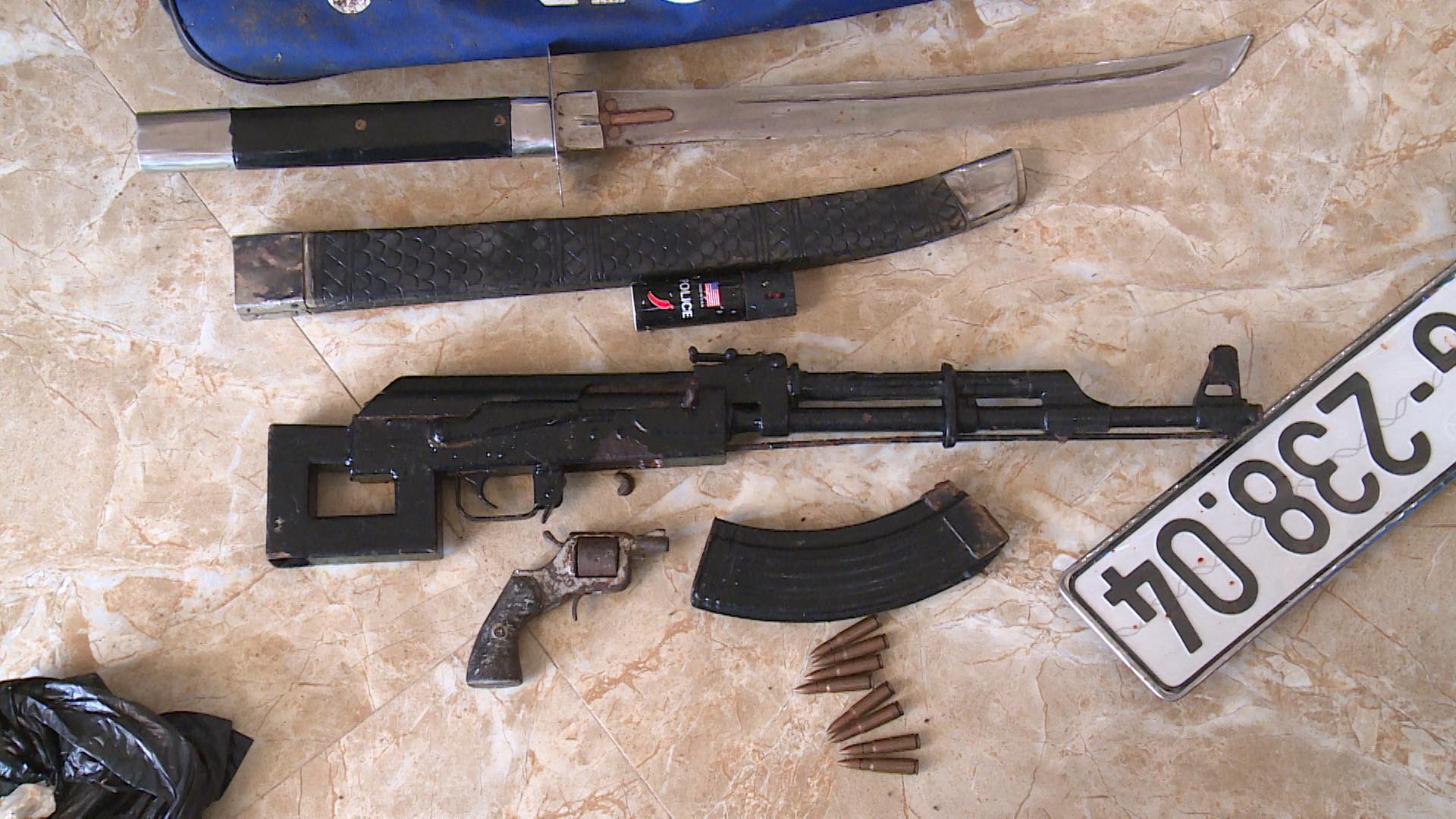 Weapons belonging to a drug ring are confiscated by officers in this supplied photo.
