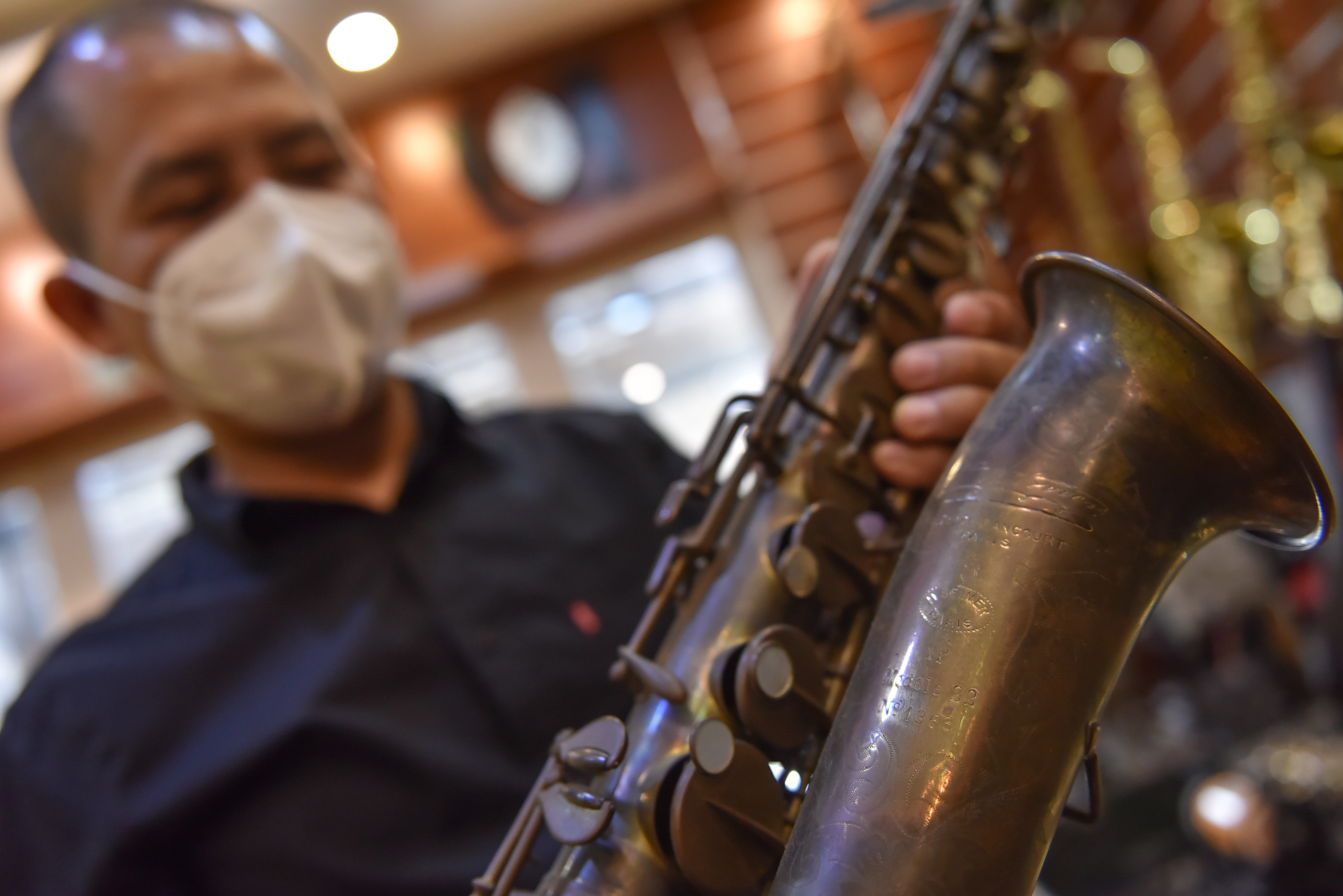 Nguyen Duy Khang holds a saxophone dated back to 1922 he collected at his repair shop in Tan Phu District in Ho Chi Minh City on December 6, 2021. Photo: Ngoc Phuong / Tuoi Tre News