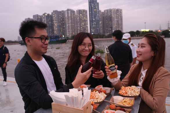 A group of friends ‘cheers’ on the water bus in Ho Chi Minh City, Vietnam, December 8, 2021. Photo: Hoang An / Tuoi Tre