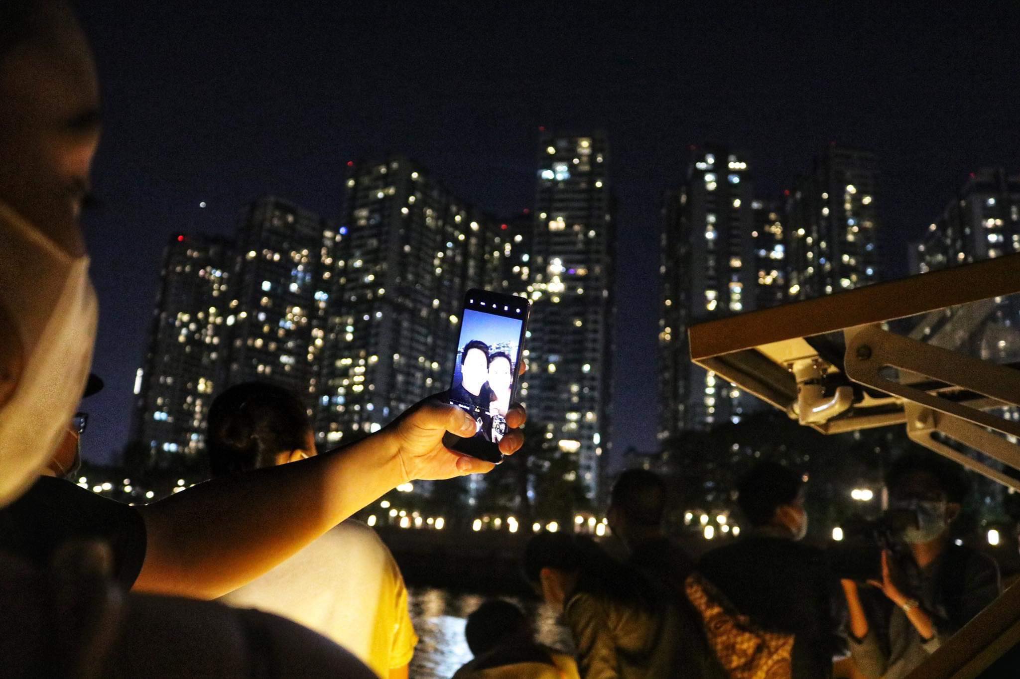 A couple takes a photo on a night water bus on the Saigon River in Ho Chi Minh City, December 10, 2021. Photo: Hoang An / Tuoi Tre