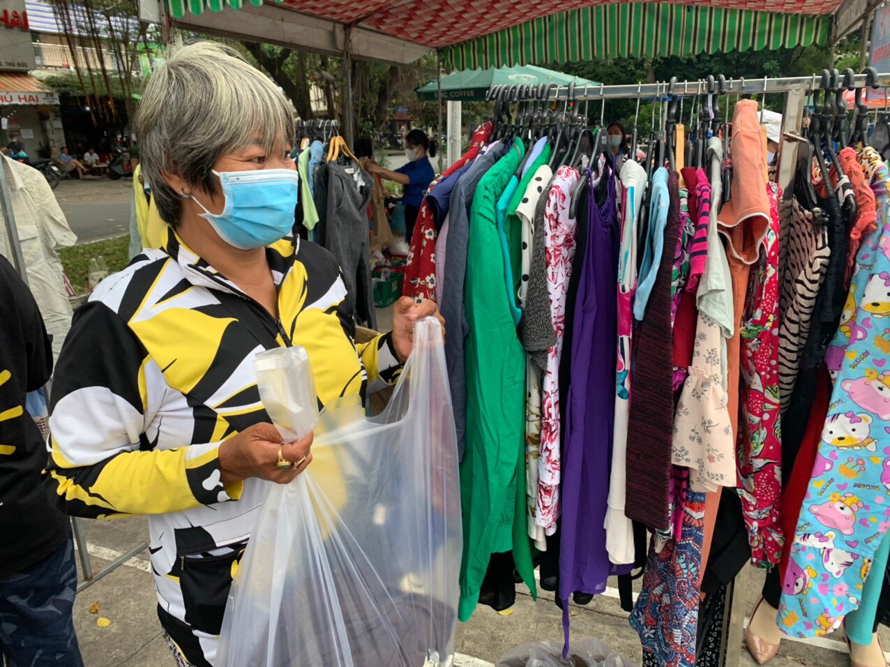 A woman browses for clothes from the ‘zero-dong clothing stalls’ in Binh Tho Ward, Thu Duc City, Ho Chi Minh City, December 11, 2021. Photo: Huu Chon / Tuoi Tre