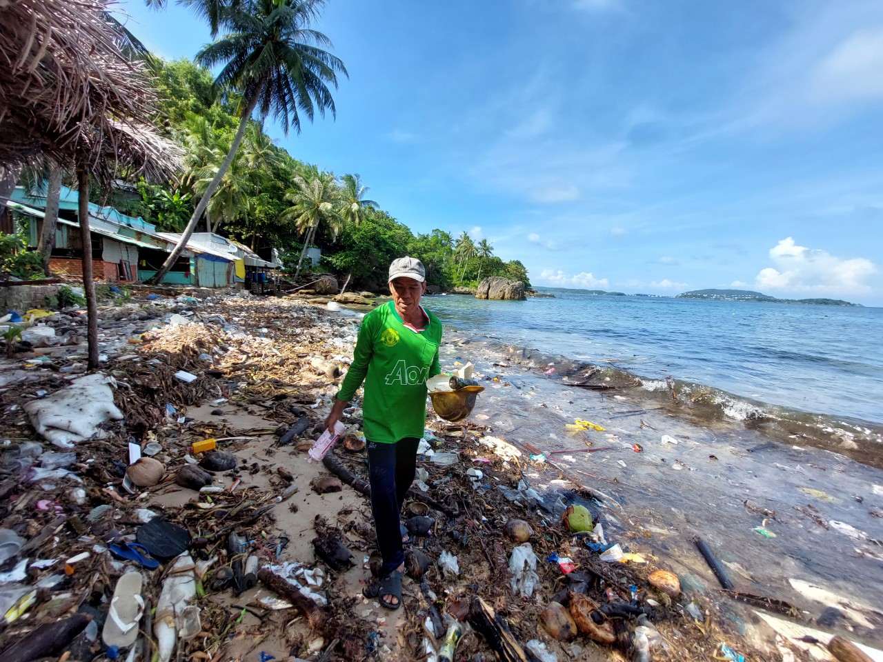Hai My walks around the beach, collecting trash along the way. Photo: Tien Trinh / Tuoi Tre