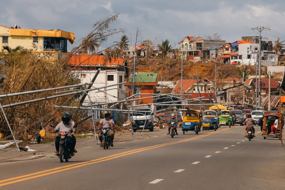 Motorists drive past fallen lamp posts following typhoon Rai in Surigao City, Surigao del Norte, Philippines, December 20, 2021. Picture taken December 20, 2021. Jilson Tiu/Greenpeace/Handout via Reuters