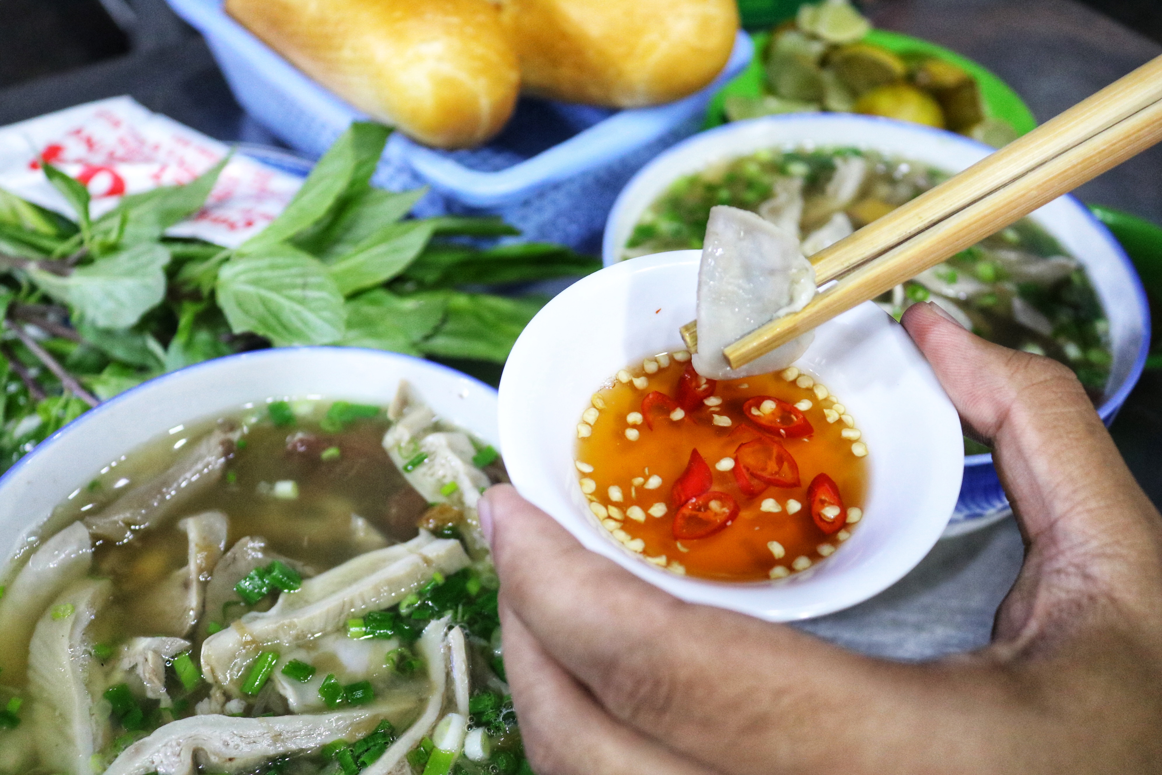 Diners dip the pig organs into a small bowl of chili and lime fish sauce served with their huyet chung. Photo: Hoang An / Tuoi Tre News