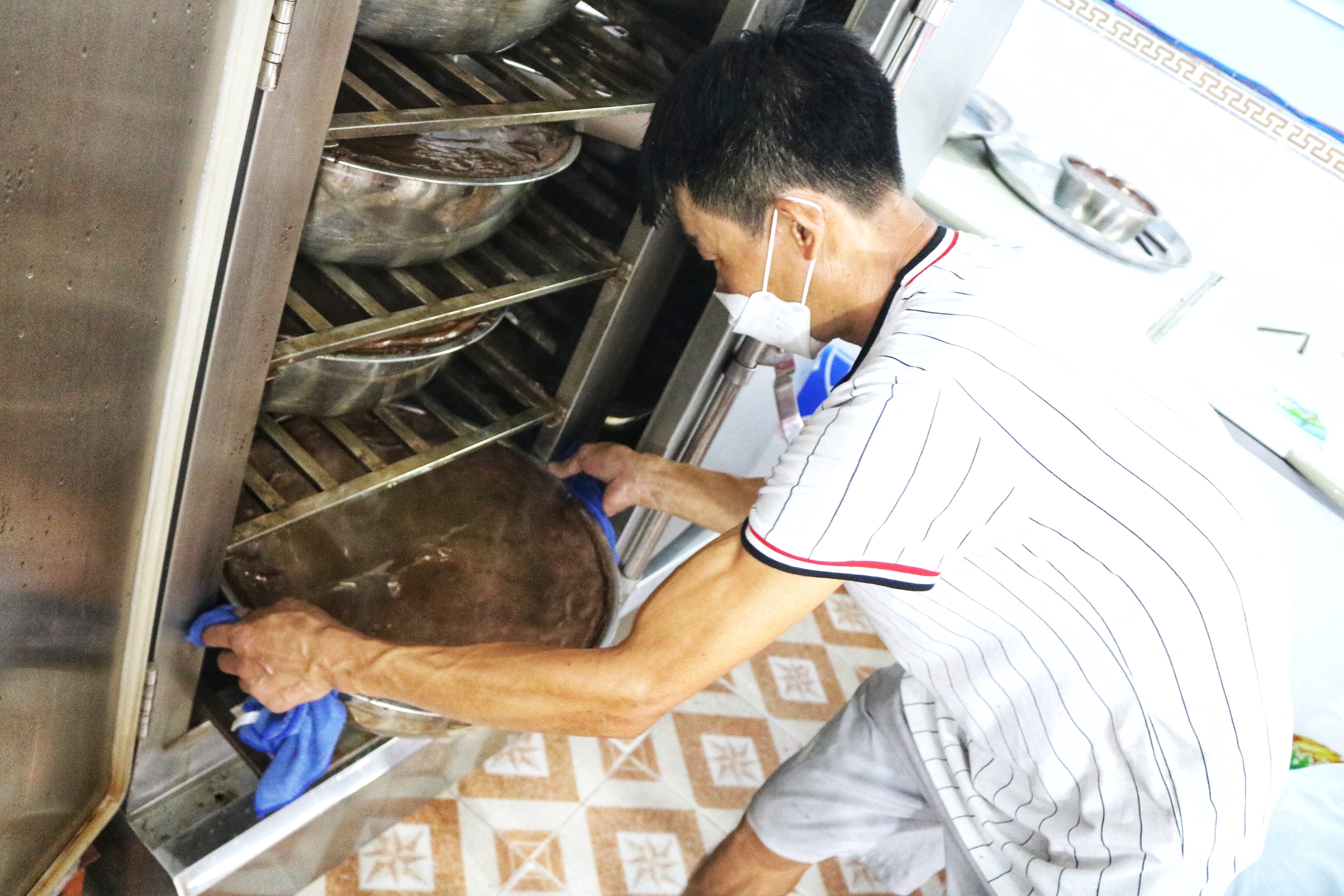 A staff pulls a huge bowl of steamed blood pudding from a 
high-pressure furnace. Photo: Hoang An / Tuoi Tre News