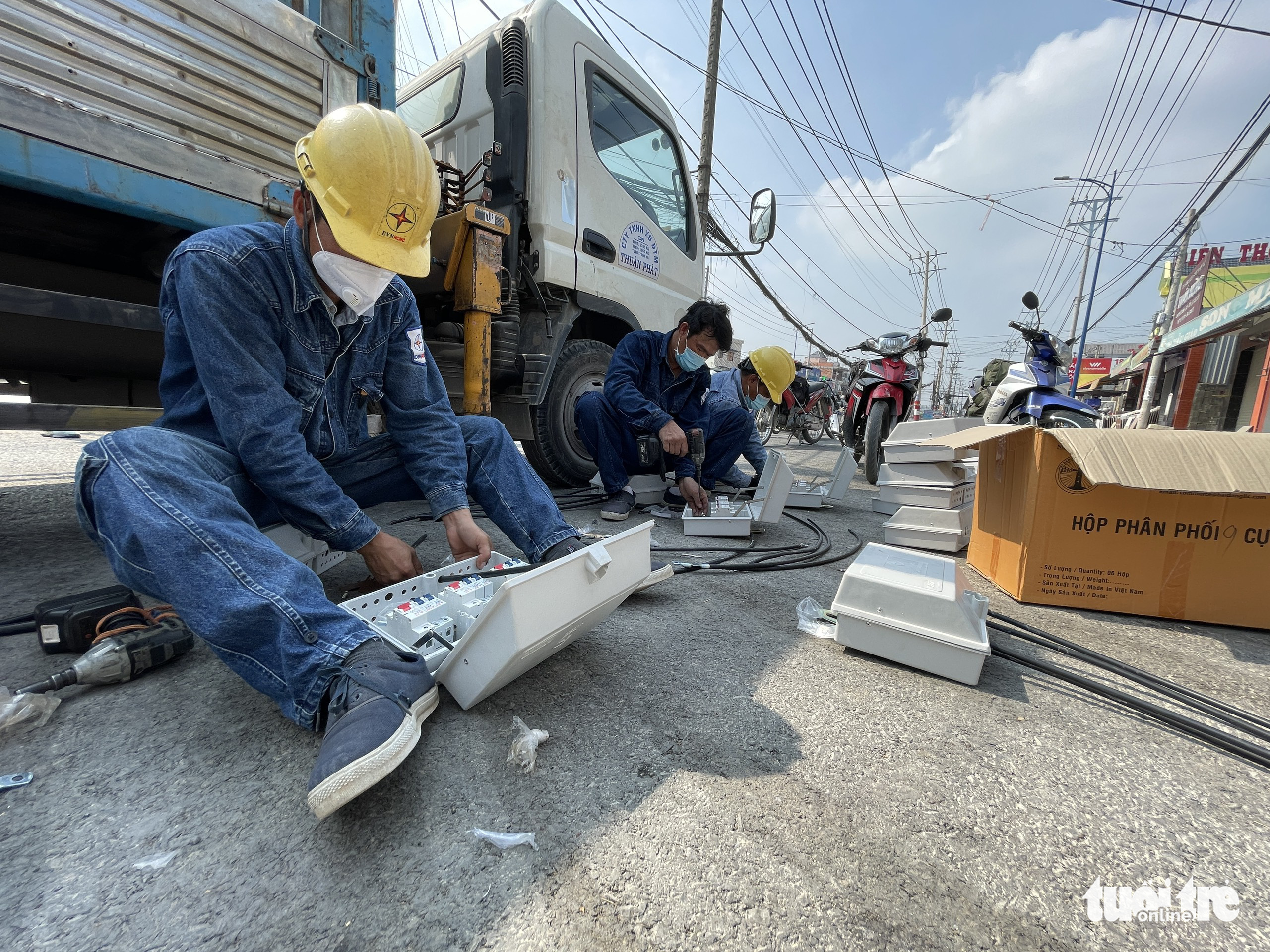 Electricity workers connect the old power line along Dang Thuc Vinh Street in Hoc Mon District, Ho Chi Minh City to the new one. Photo: Le Phan / Tuoi Tre