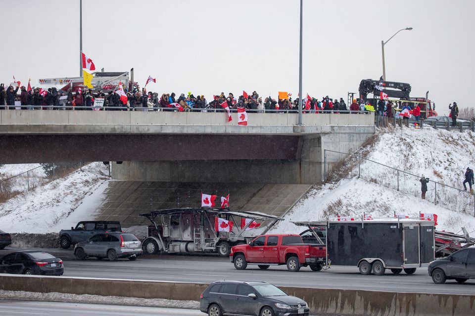 Supporters of truckers gather on a highway overpass in Toronto, Ontario, Canada, to support truck drivers on their way to Ottawa to protest coronavirus disease (COVID-19) vaccine mandates for cross-border truck drivers January 27, 2022. Photo: Reuters