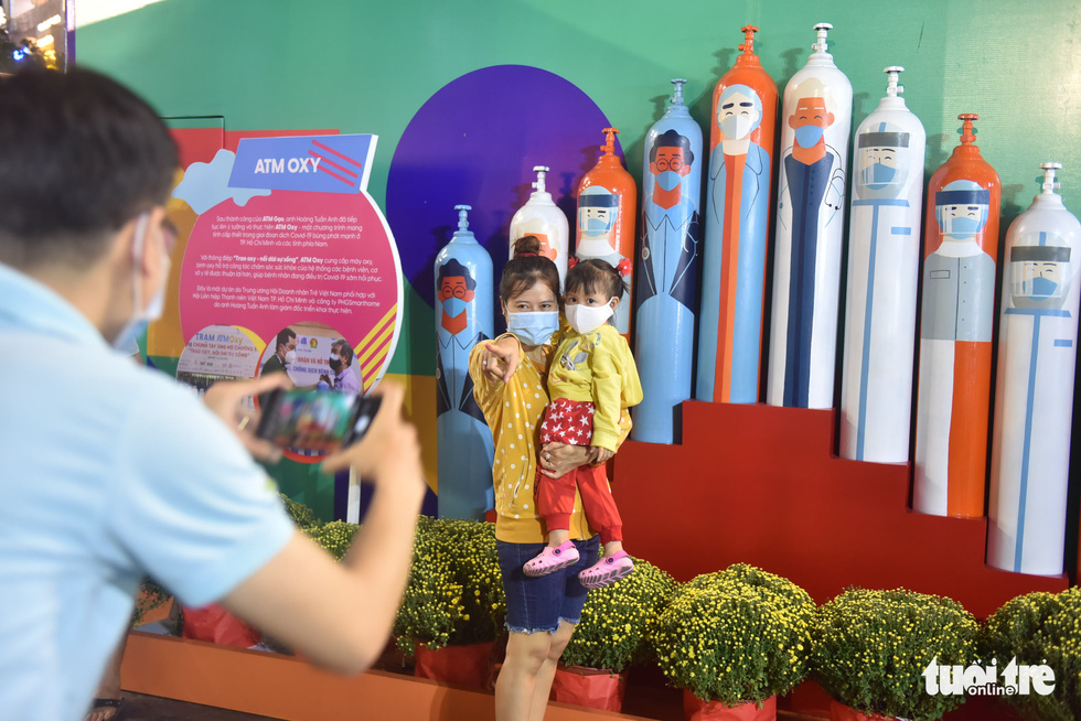 A woman and her child pose for a photo with the oxygen ATM background on the Nguyen Hue Flower Street in District 1, Ho Chi Minh City, January 29, 2022. Photo: Tuoi Tre