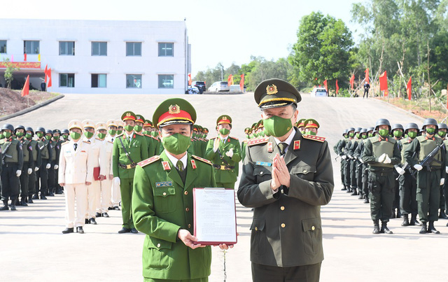 General To Lam (right), Minister of Public Security, hands the decision to establish a national center for counter-terrorism training to Lieutenant General Pham Quoc Cuong, Commander of the Mobile Police Command, during a ceremony in Quang Ninh Province, Vietnam, February 23, 2022. Photo: Vietnam Government Portal