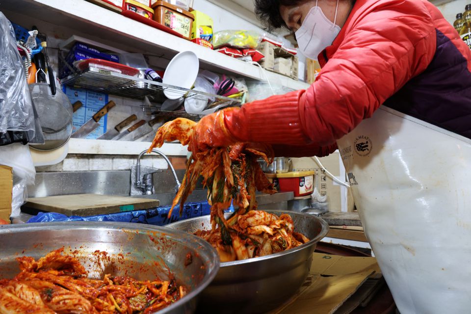 Choi Sun-hwa makes a traditional Korean side dish kimchi at her side dish store at a traditional market in Seoul, South Korea, April 7, 2022. Photo: Reuters