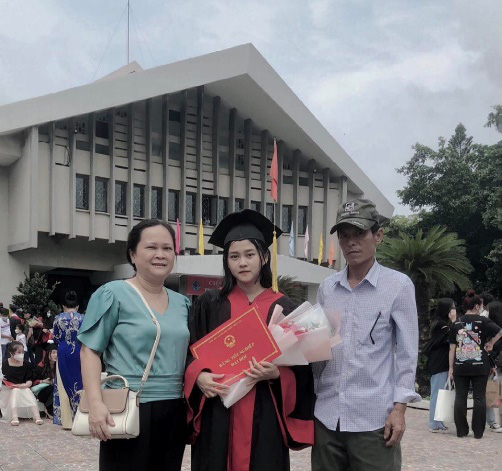 Le Thi Kim Thy and her parents pose for a photo.