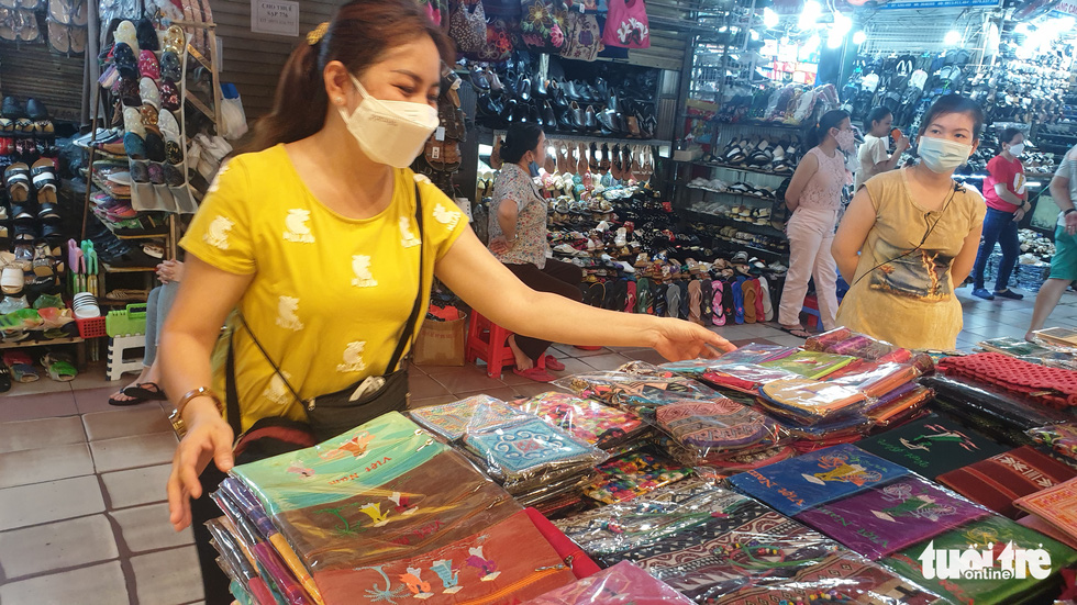 Le Hong Loan, owner of a souvenir shop, said that she had yet to dare to purchase new items for selling as she had to handle inventories and calibrate the consumption. Loan expects to see a surge of 40 percent to 50 percent in the consumption in the coming months after the country fully reopened its doors to the world. Photo: N.Tri / Tuoi Tre