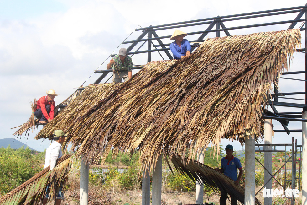 Locals assist each other to repair a roof at Dong Ho Lagoon, Ha Tien City, Kien Giang Province. Photo: C.Cong / Tuoi Tre