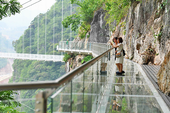 Visitors stand on the walkway section of the Bach Long glass bridge in Moc Chau district in Vietnam’s Son La province. Photo: AFP